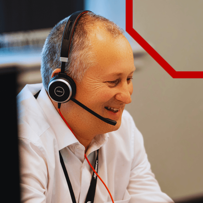 A member of the analytics team on a headset at a workstation