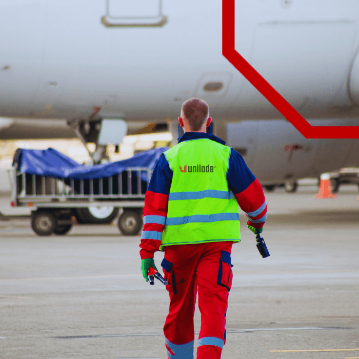 A Unilode team member walking the ramp beside tagged ULDs