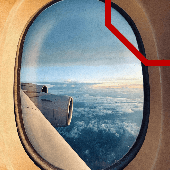 View of an aircraft engine and wing through a cabin window