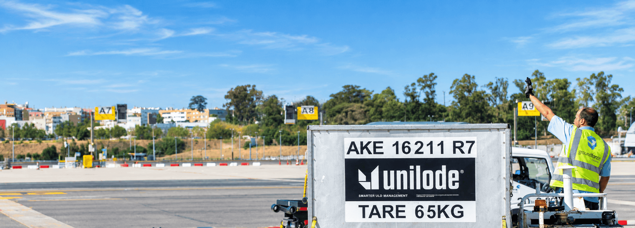 A Unilode AKE container on the apron while a ground handler signals to the aircraft