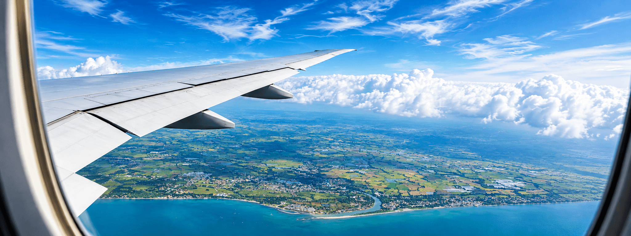 An aircraft wing above the clouds, seen from a cabin window